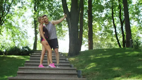 Happy couple running downstairs and doing selfie photo on mobile phone