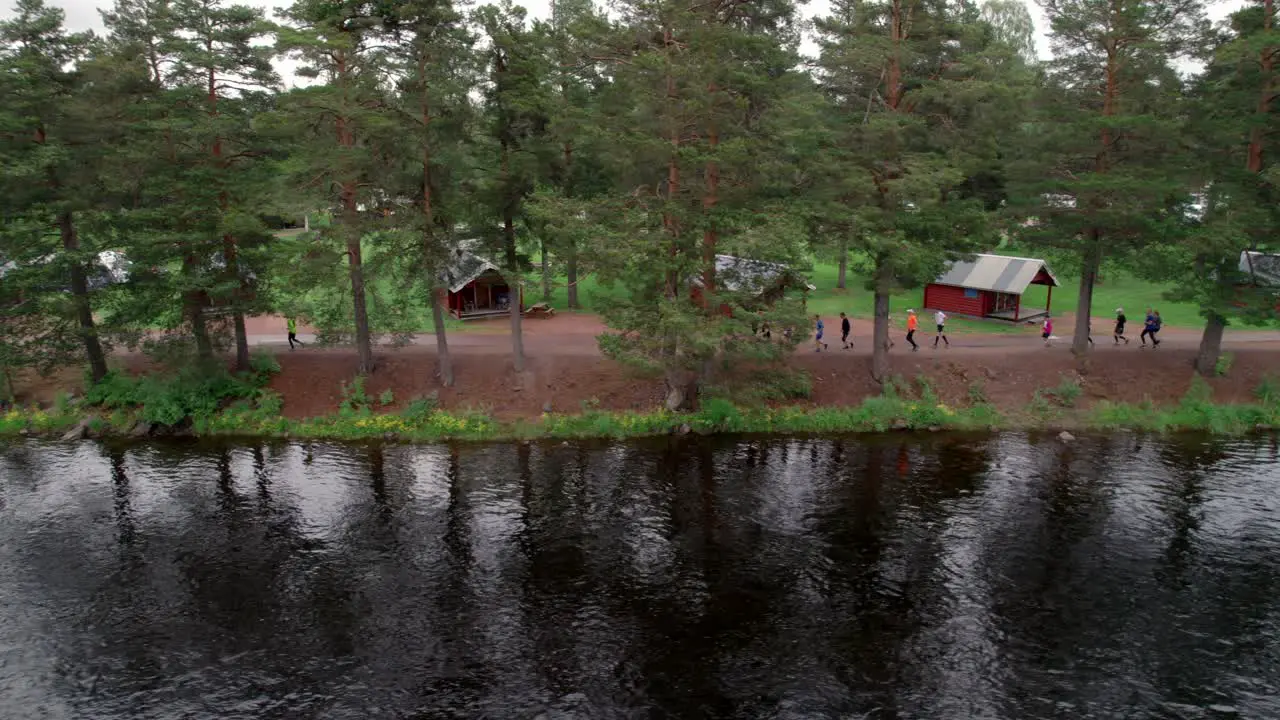 Group Of People Jogging Along River Fitness Concept Sideways Aerial