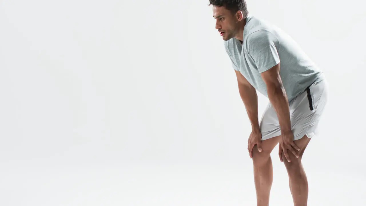 Young biracial athlete man takes a break from exercising on a white background with copy space