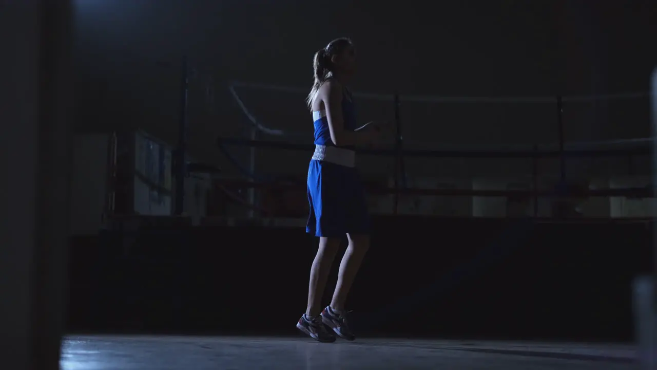 Woman jumping in the Boxing hall on a rope