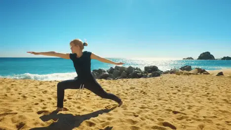 Woman practicing balance yoga asana on coast of sea Fit girl in yoga pose