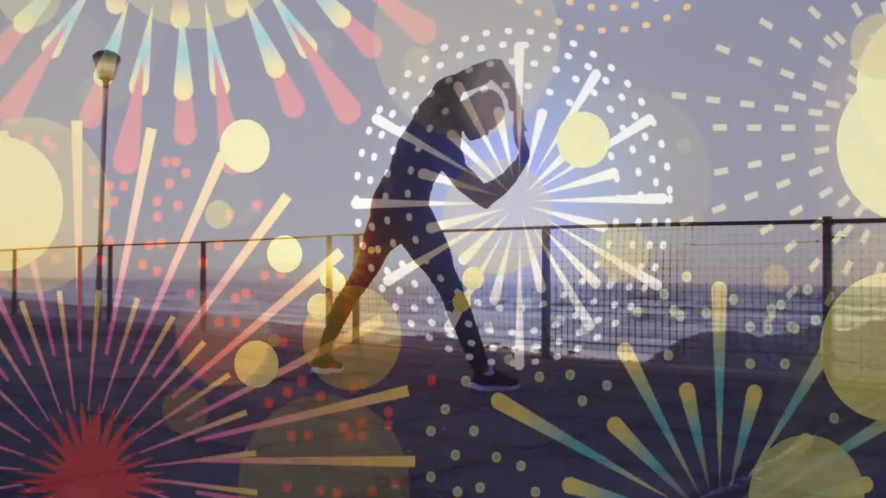 Fireworks icons against african american fit man performing stretching exercise at the promenade