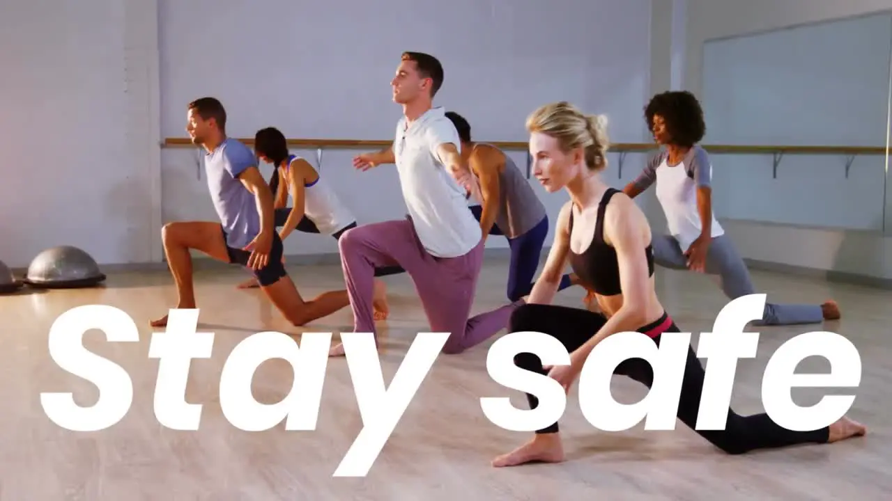 Stay safe text against group of people practicing yoga at the studio