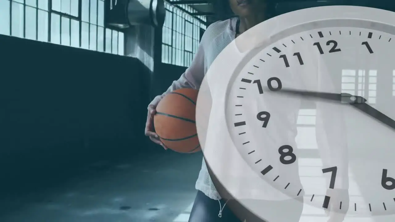 Digital composite video of clock ticking against african american woman holding basketball