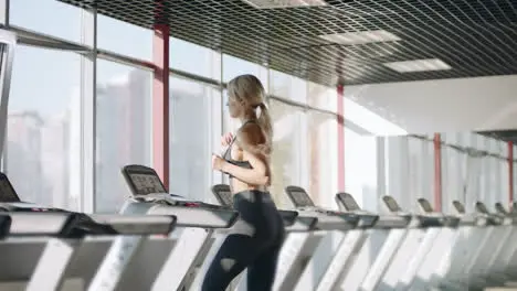 Fitness woman running on treadmill in gym Pretty girl having cardio training