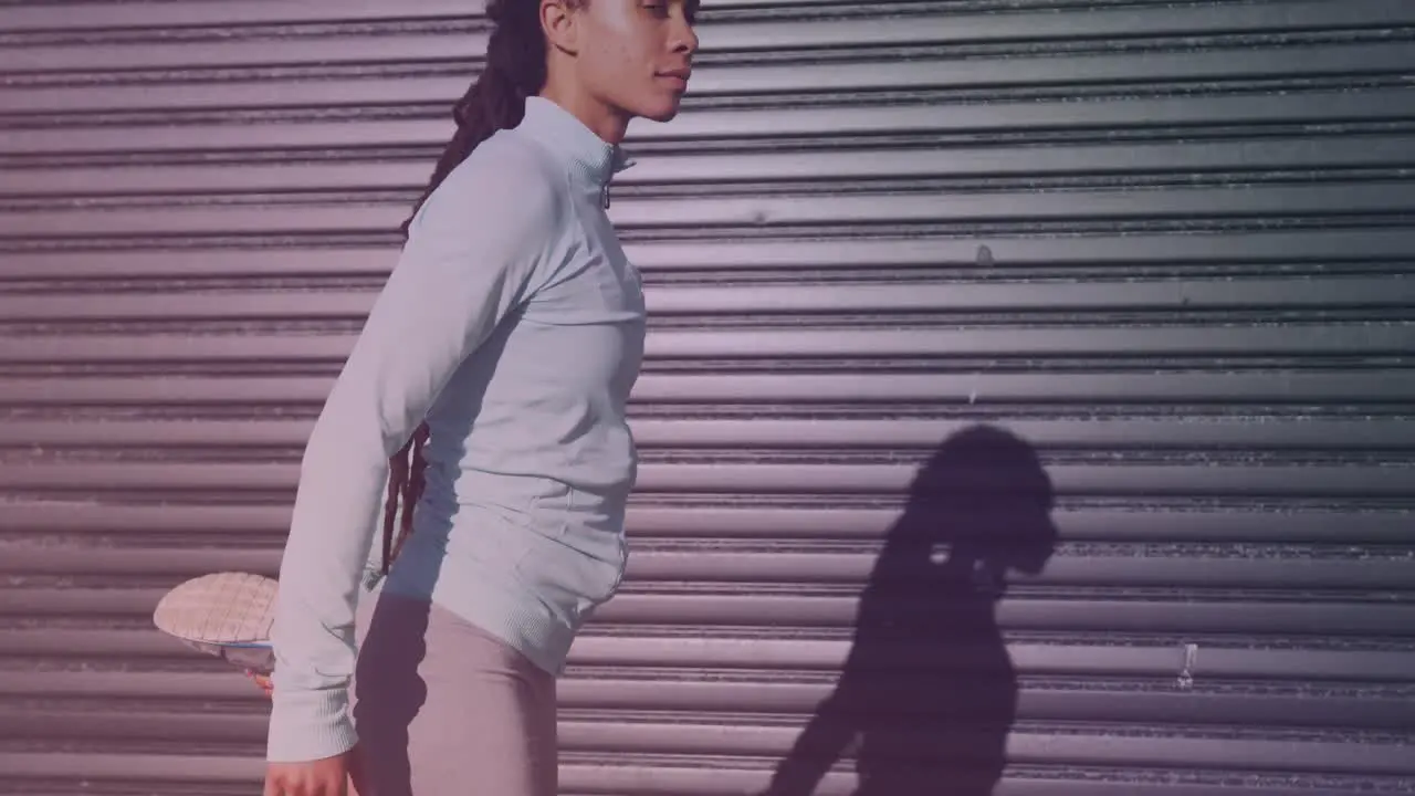 African american fit woman in sportswear stretching her leg by the street