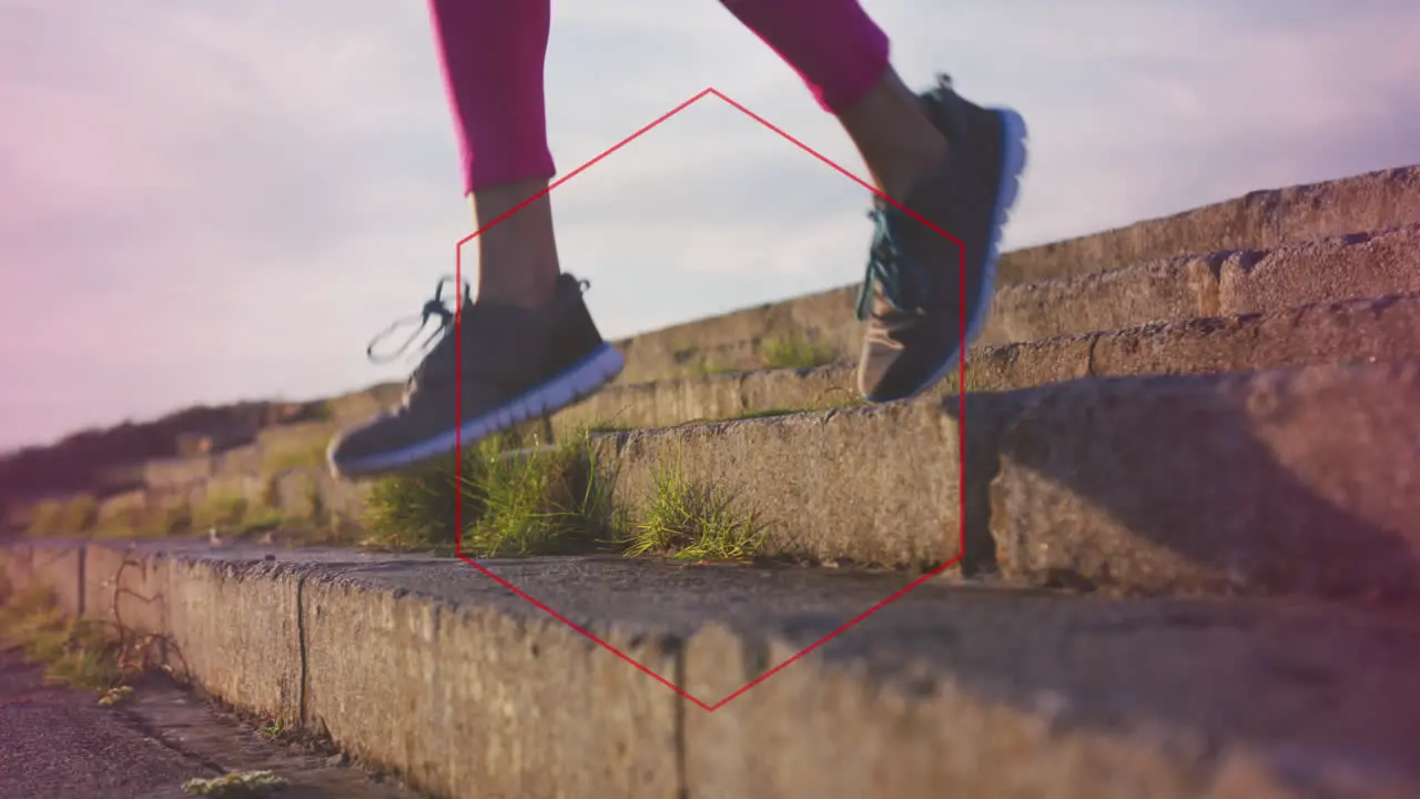 Red hexagonal shape against low section of a woman running down the stairs