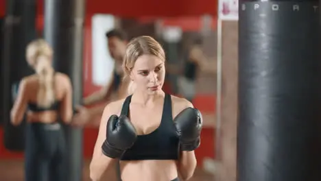 Woman boxer training punches on boxing training with coach together