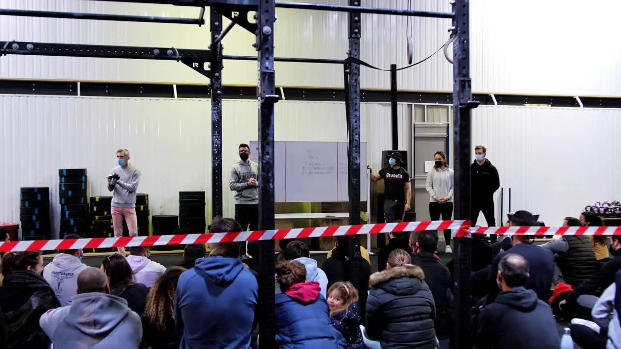 CrossFit Competition Briefing Coaches Presenting Program on Whiteboard to Seated Athletes