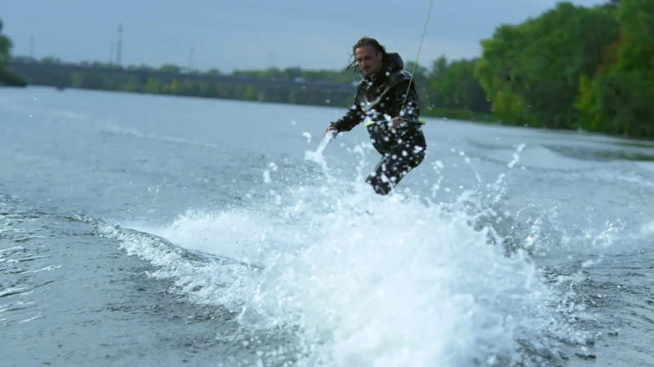 Wake skier making tricks on waves during movement