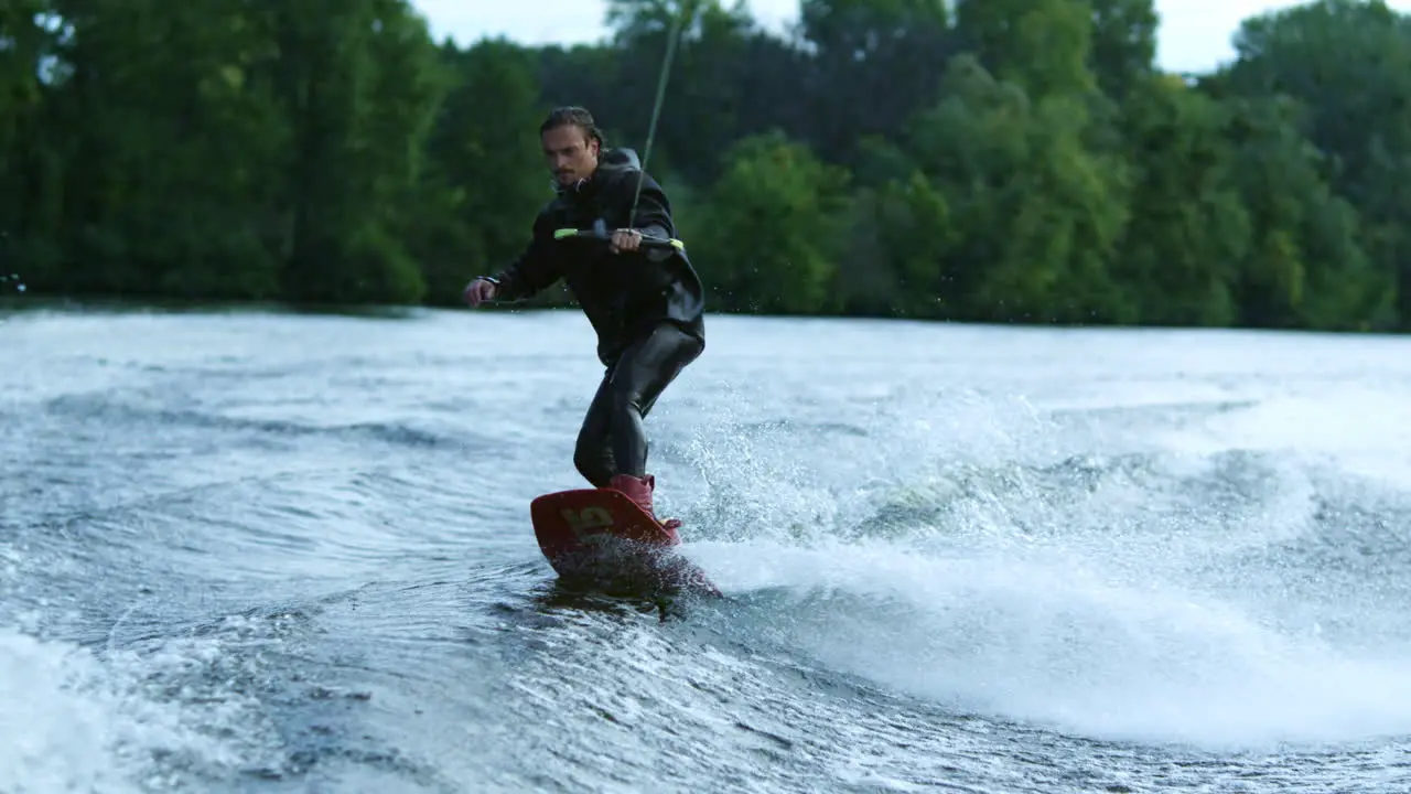 Young man wakeboarding on river wave