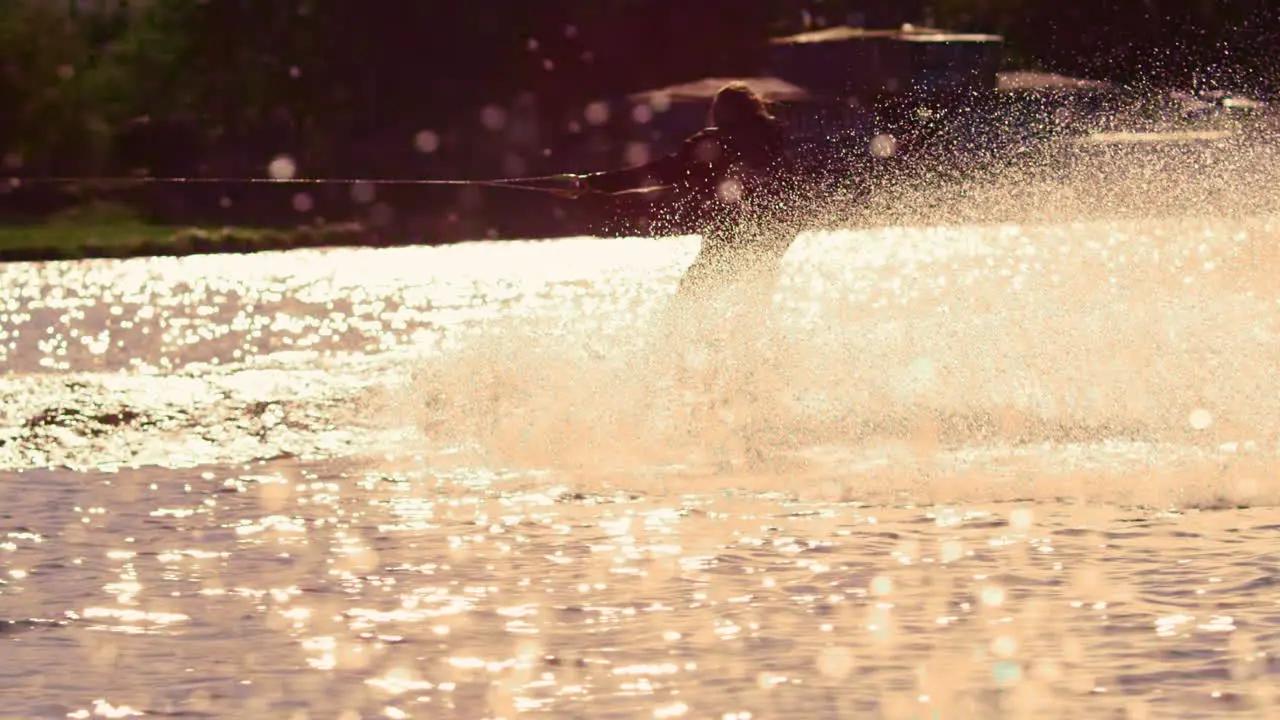 Man riding wakeboard at sunset