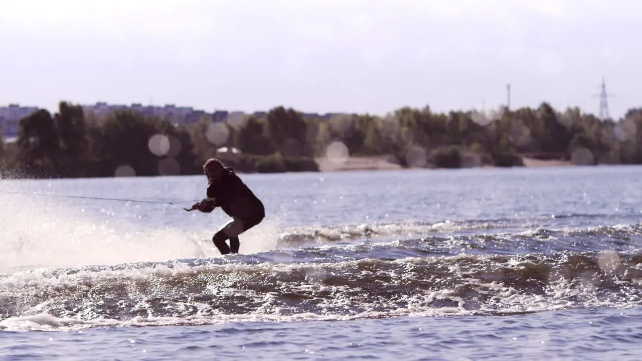 Guy riding wakeboard on wide river