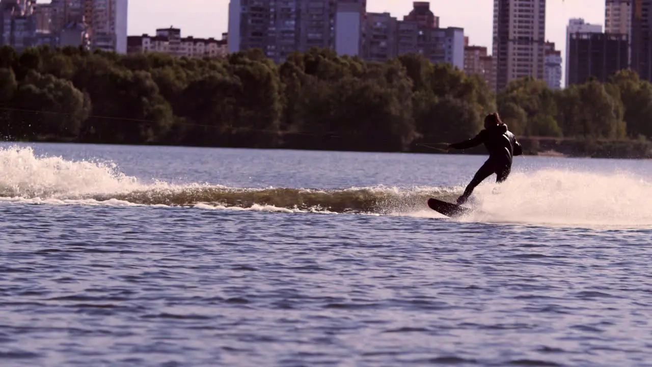 Guy rushing along lake on water board in slow motion