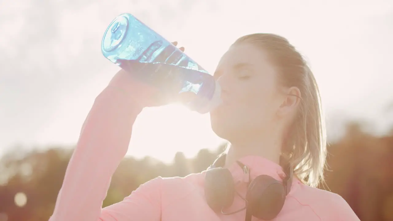 Handheld view of woman drinking water after hard workout