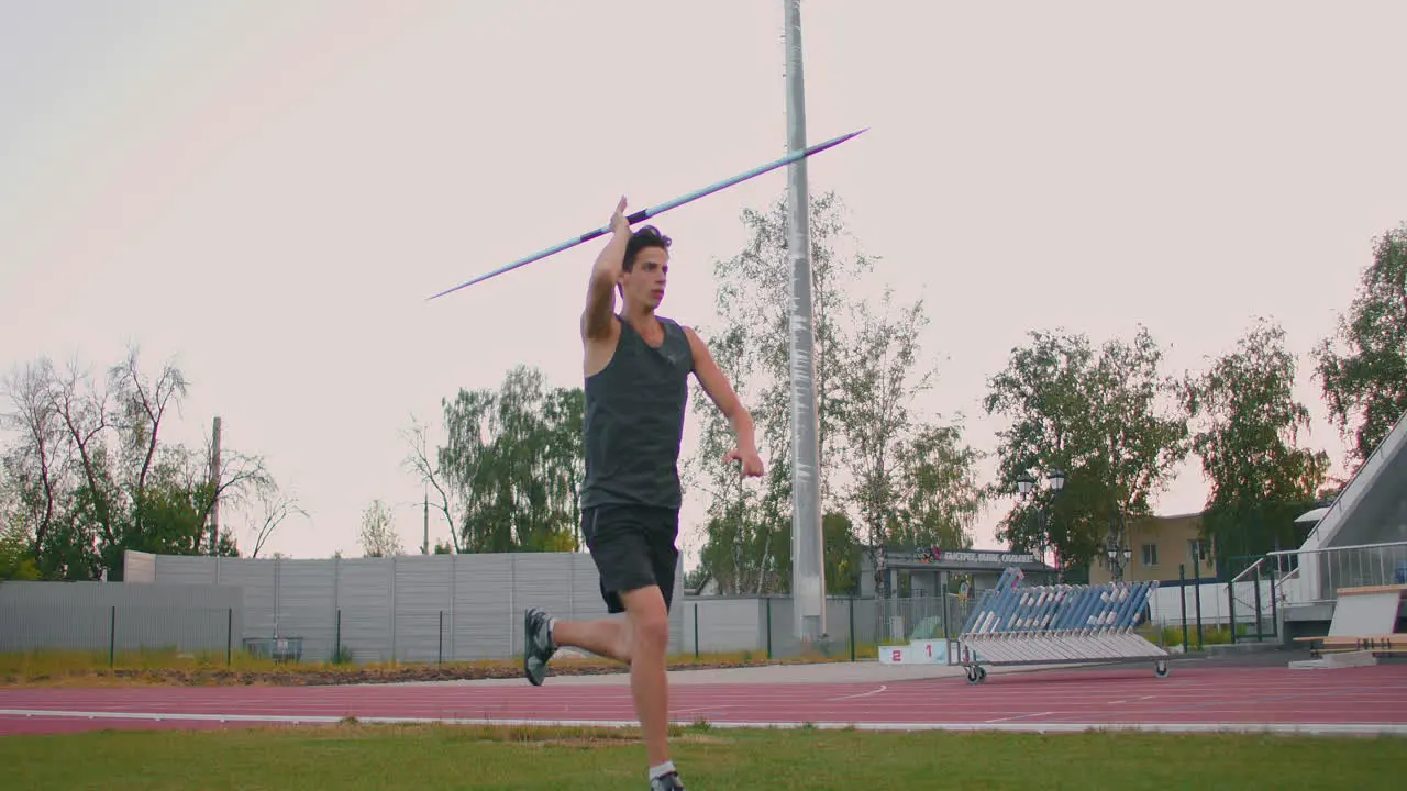 A male athlete throws javelins at a stadium in slow motion Athletics javelin throw Olympic program