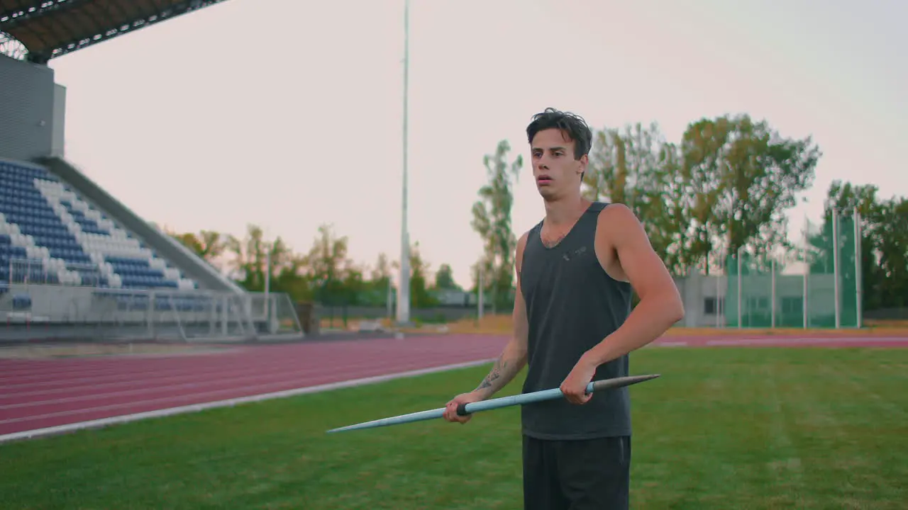 Slow motion a Male athlete at the stadium concentrates and prepares to do a javelin throw Attitude and serious expression Goes around collecting spears Training of a javelin thrower