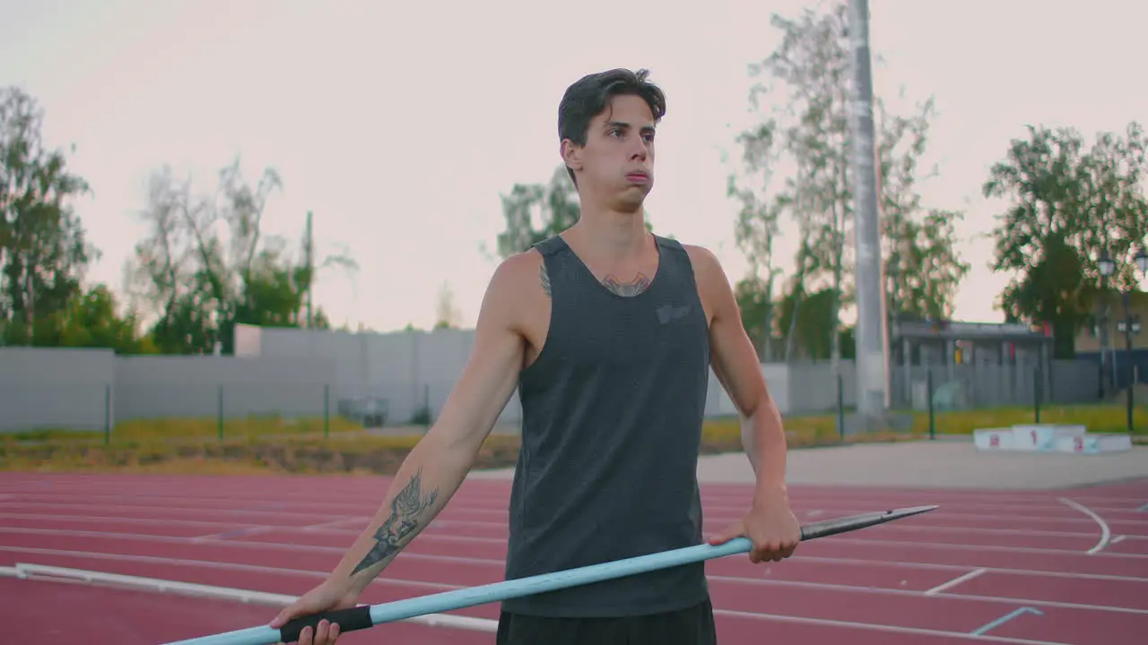 Sportsman doing javelin throw on athletic ground Male athlete throwing the javelin in the olympic stadium Athlete in sport clothes at athletic sport track in professional stadium