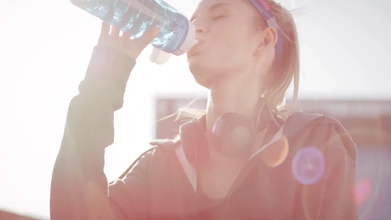 Tilt up view of woman drinking water after hard workout