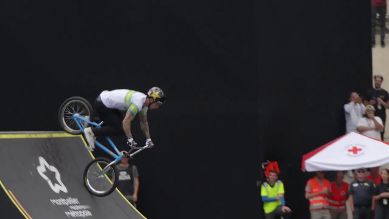 At the skate park a young man fearlessly executes daring tricks on a bike defying gravity and performing impressive maneuvers at great heights