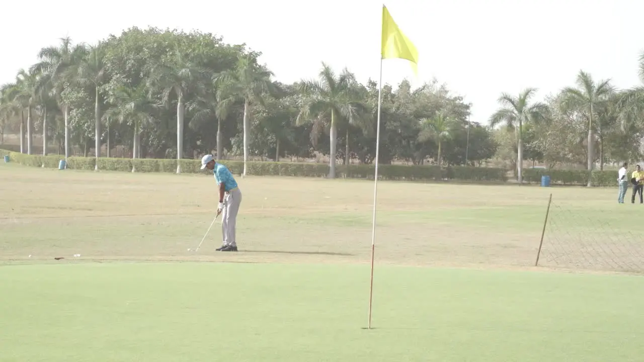 very wide scene in which the golfer is bringing the ball closer by hitting short