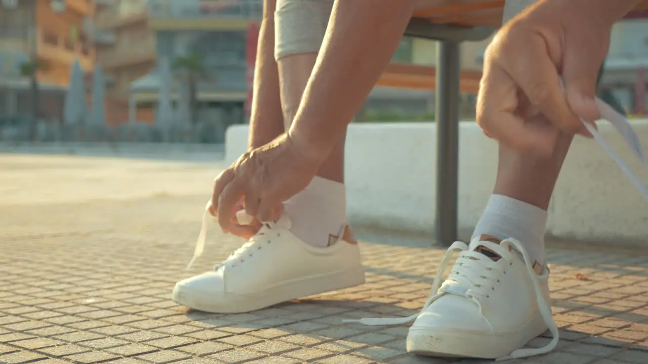 Mature couple lacing running shoes before jog