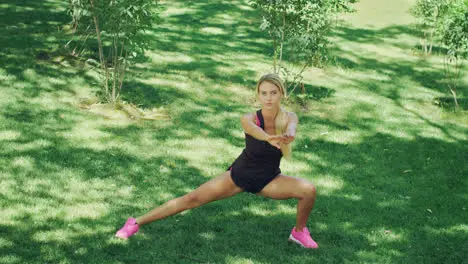 Fitness woman doing stretching squat Fit girl warming up before sport training