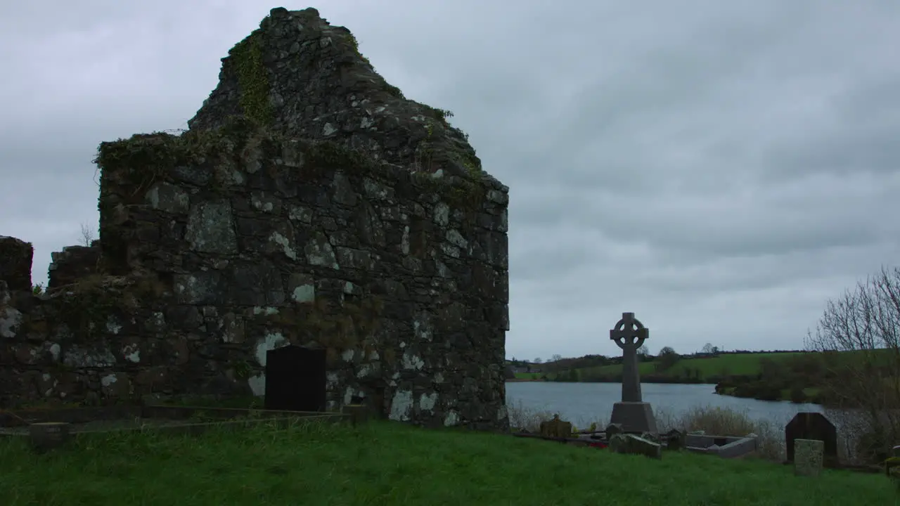 Ruin Of An Old Stone Church With Graves over lake Ireland