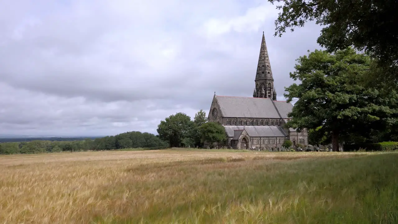 UK church and steeple overlooking hayfield village and tree lined