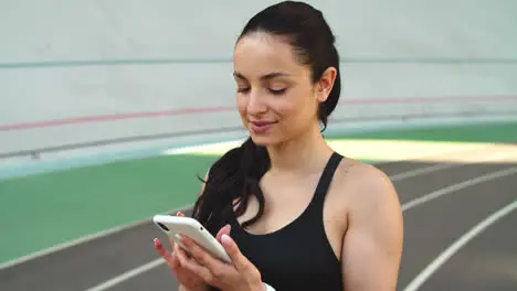 Fitness woman looking smartphone outdoors Female runner using phone