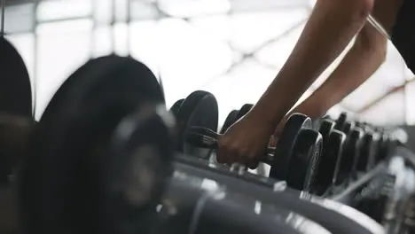 Female hands finishing weight training in fitness club