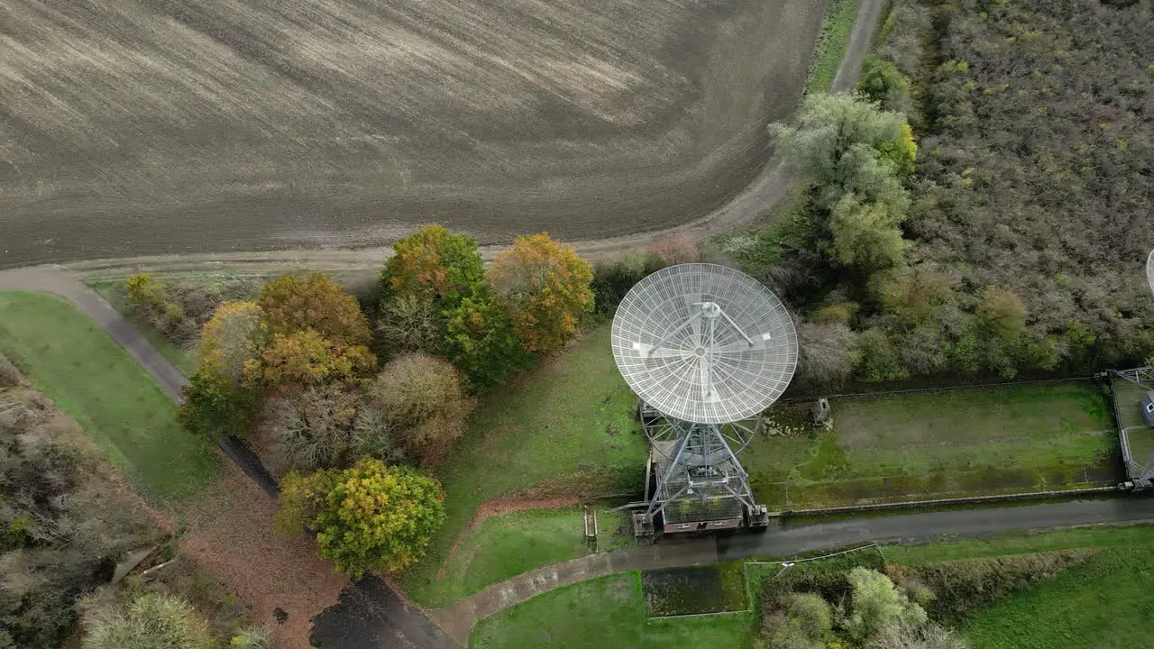 Aerial view flying across Mullard MRAO radio observatory dishes on Cambridge farmland