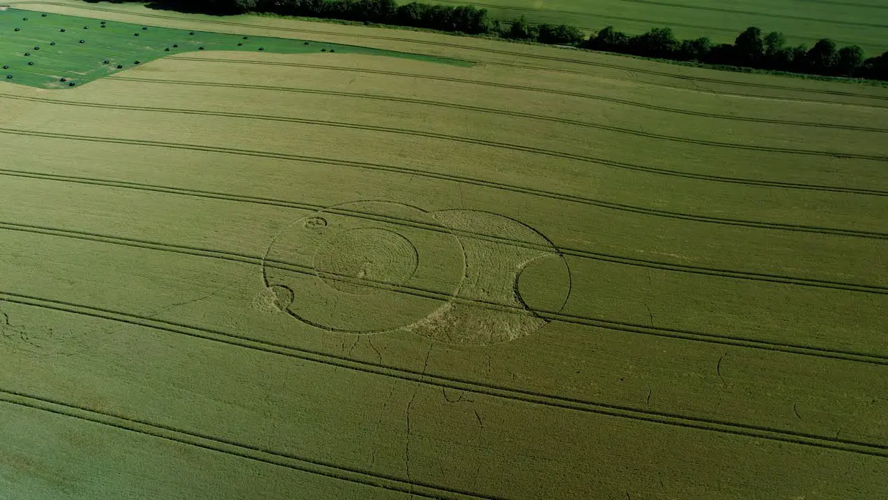 Wootton rivers Wiltshire paranormal crop circle pattern in green farmland field aerial drone view rotating right