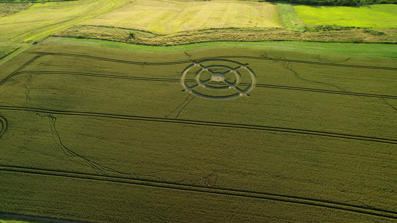 Hackpen hill strange crop circle pattern in rural grass farming meadow aerial view wide left rotating shot