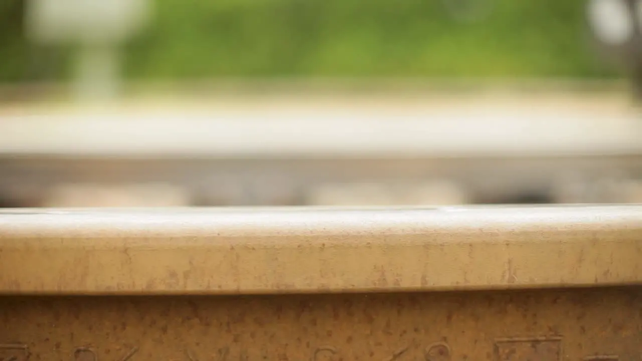 Close-up of a rusty rail track with a dolly-in shot focus on the texture and details indicating an upcoming journey or travel