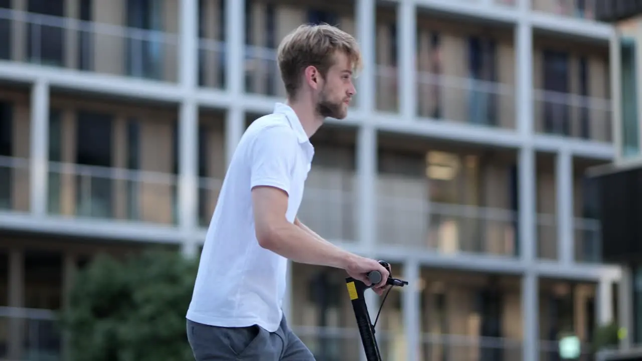 Young businessman walking to his e scooter and driving off