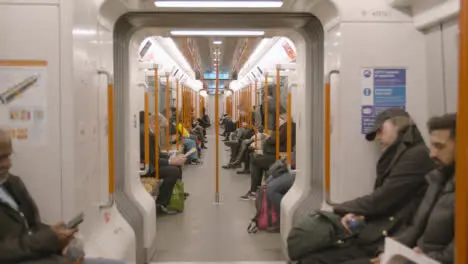 Interior Shot Of Passengers Commuting In Carriage Of UK Train In Early Morning 1