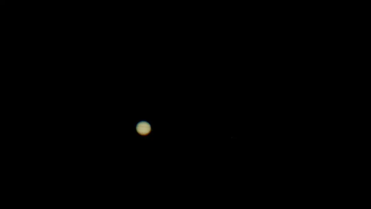 Jupiter as seen in backyard telescope large magnification with four Galilean moons