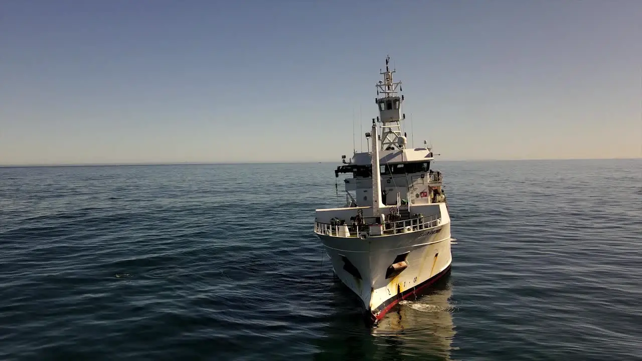 Marine research vessel seen from the bow using its crane on the open ocean