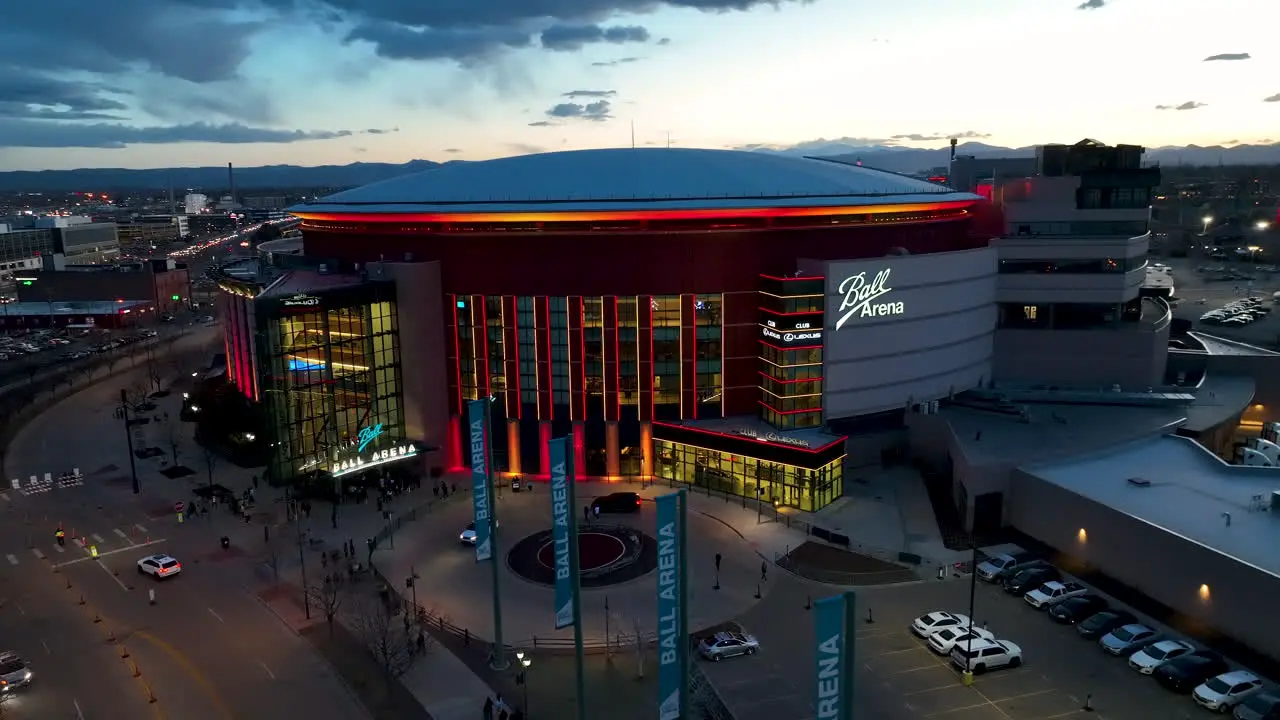 Twilight aerial pullback of Ball Arena in Denver colorful lighting on exterior