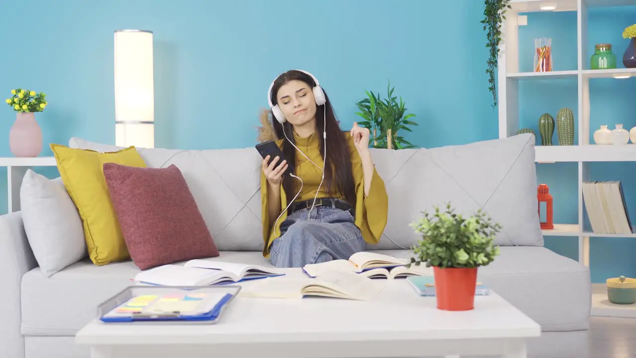 Young girl listens to music with headphones at home