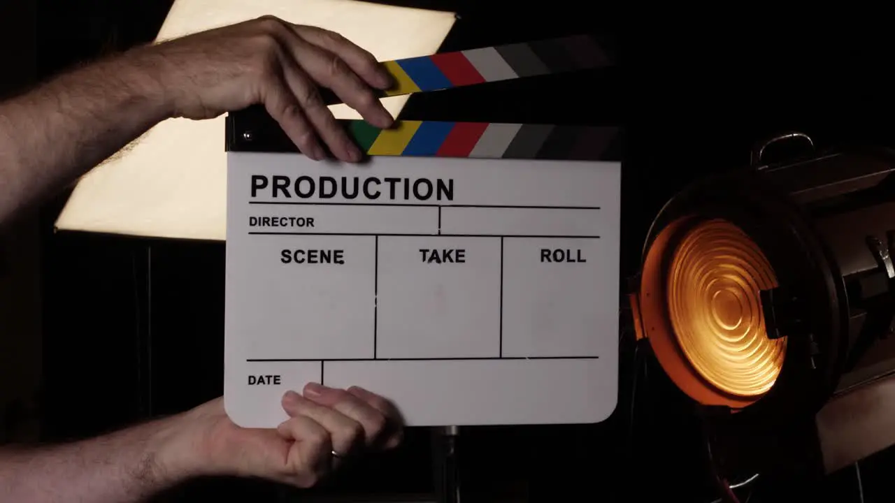 Movie slate or clapboard raised into the frame and clapped in a movie studio