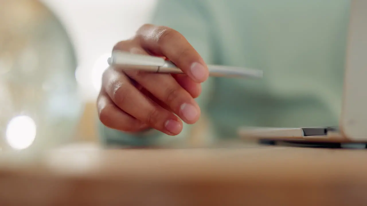 Laptop hand and holding a pen on a table