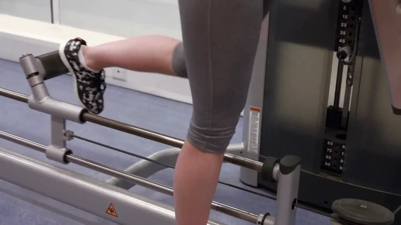 Woman using weights machine in gym