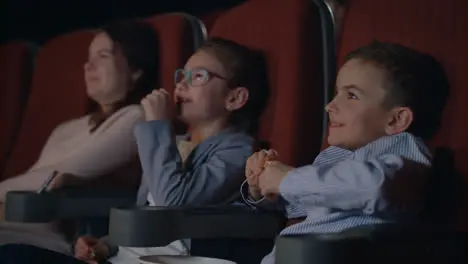 Children watching movie enthusiastically in cinema Child entertainment concept