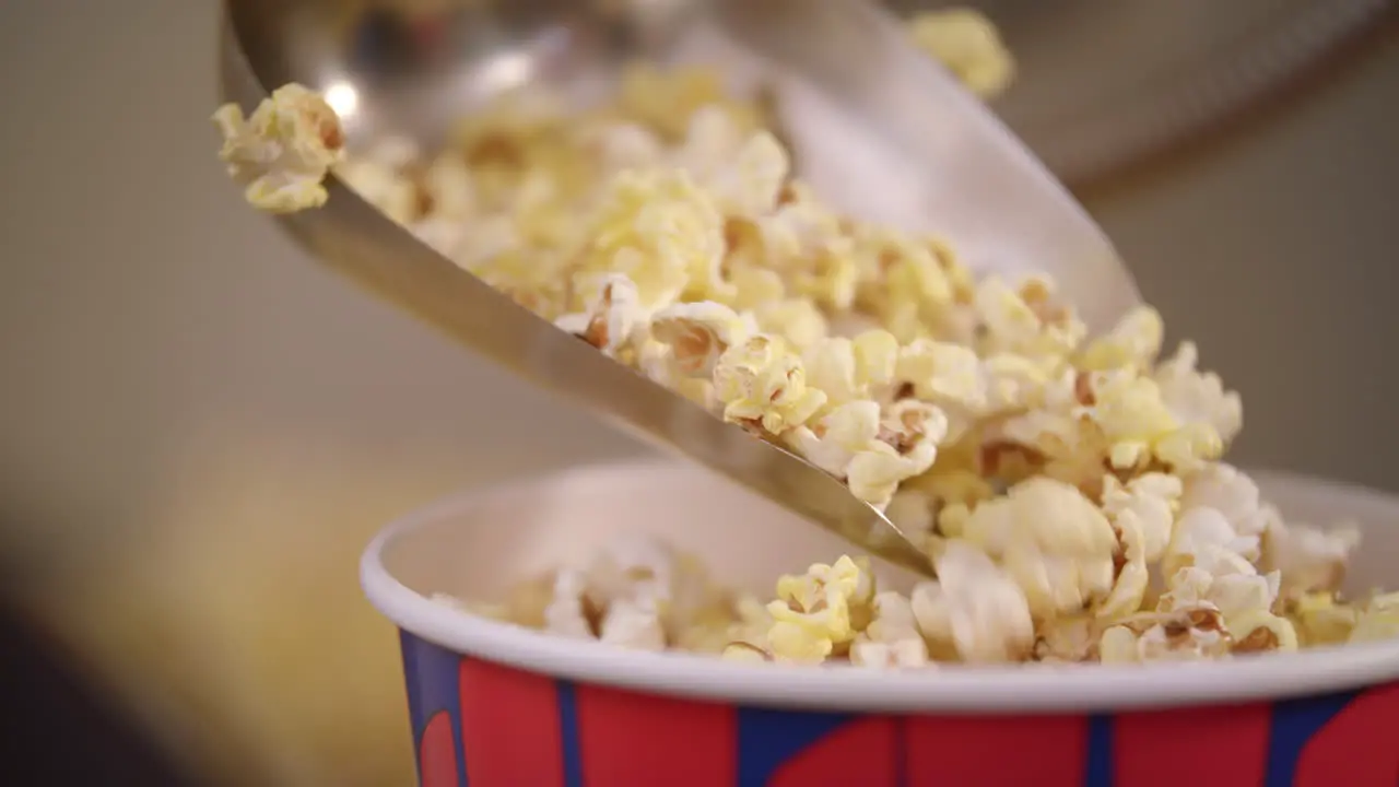 Popcorn flakes pouring by ladle to paper container in slow motion