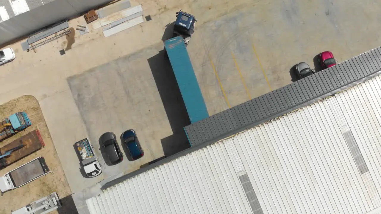 Blue container truck reversing into a warehouse