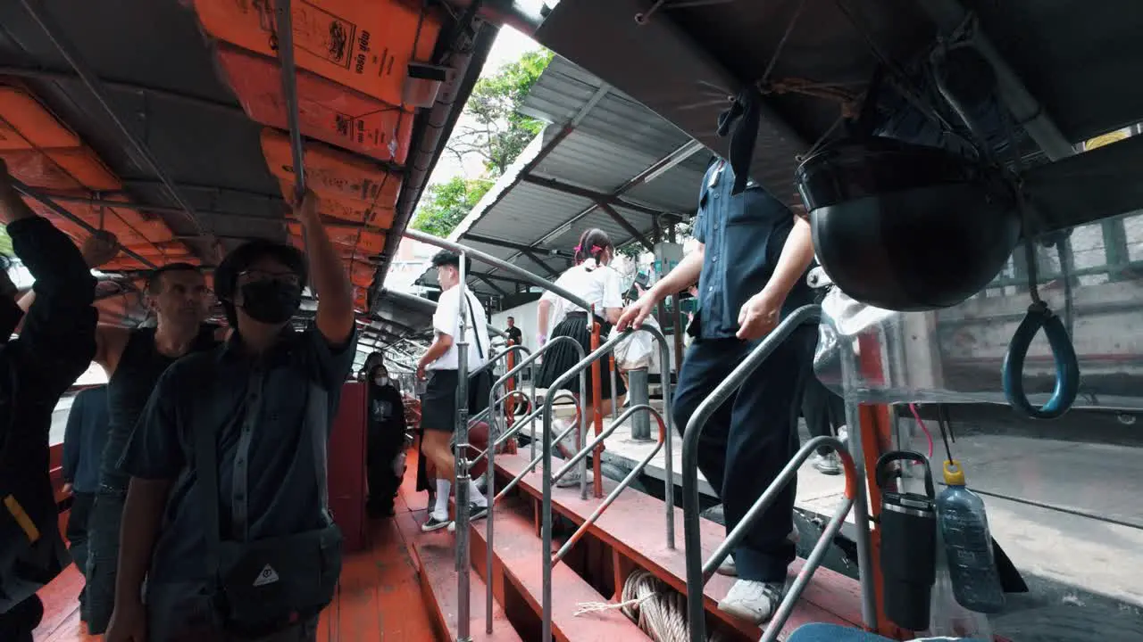 People getting on and off the transportation boat in Bangkok