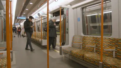 Interior Shot Of Commuter Passengers Getting Off UK Train At Station