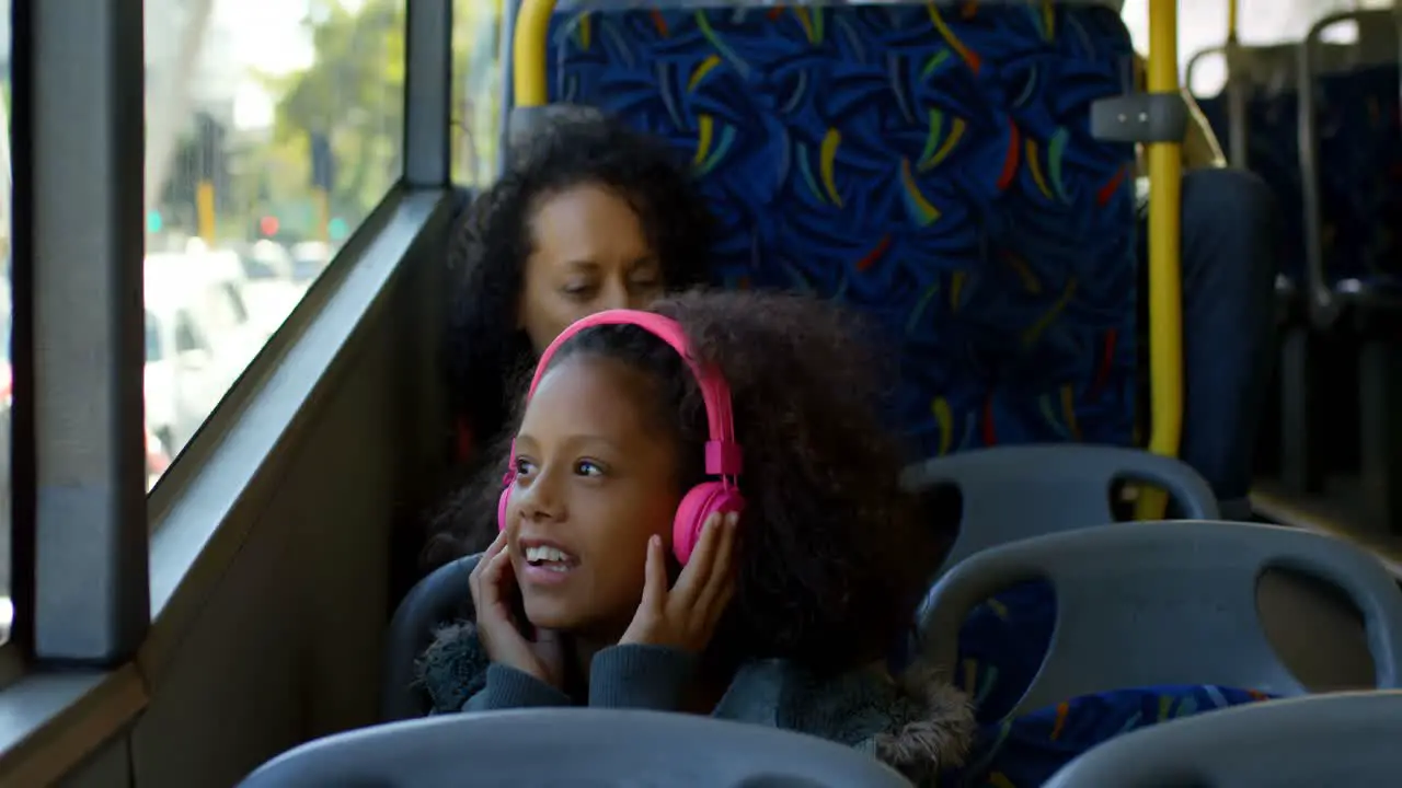 Girl listening music on headphones while travelling in bus 4k